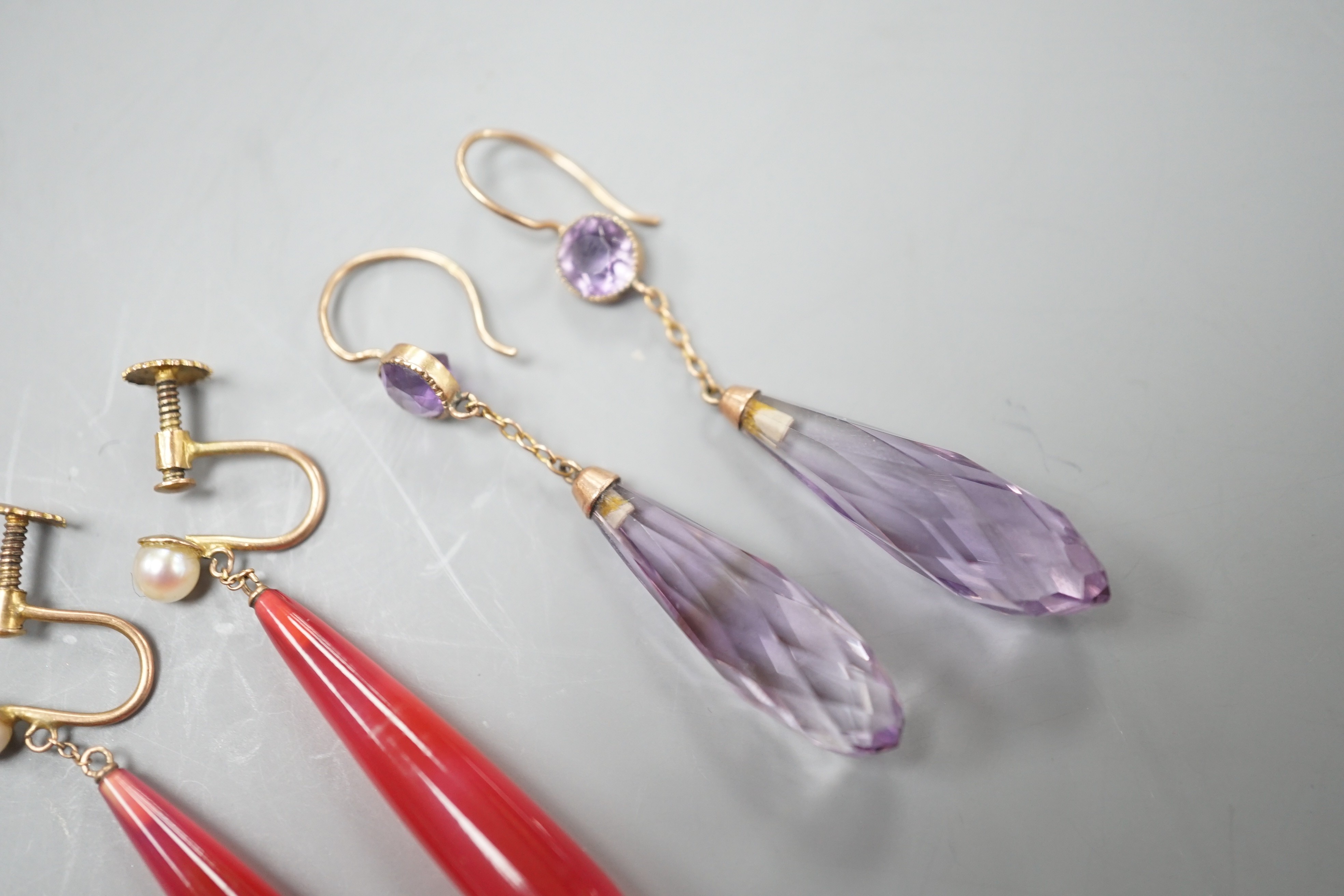 A pair of yellow metal and two facetted amethyst drop earrings, overall 49mm and a pair of 9ct, red carnelian? and seed pearl set drop earrings.